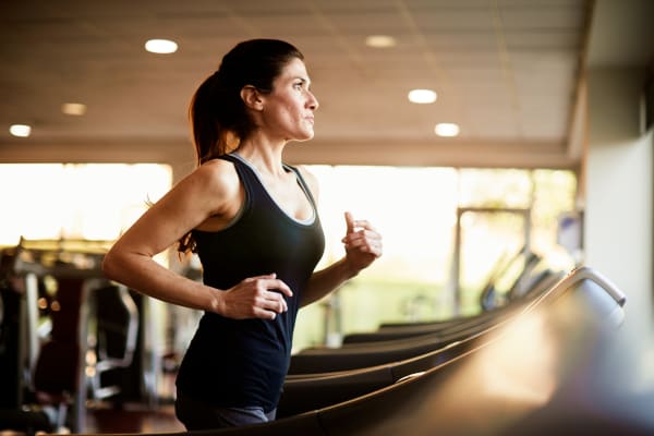 A woman running on a treadmill in the fitness center at Fairway View in Hialeah, Florida