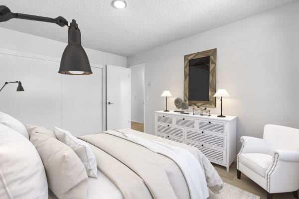 Spacious bedroom decorated in white tones at Vista Apartments in Chula Vista, California