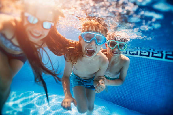 Happy kids swimming in a pool at Castellino at Laguna West in Elk Grove, California