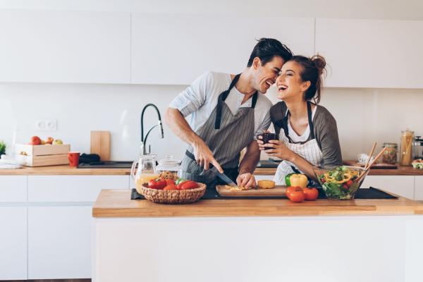 Happy couple cooking together at Cherry Blossom Apartments in Sunnyvale, California