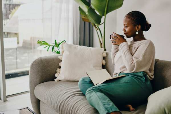 A woman in her new apartment enjoying a cup of coffee at Flatiron District at Austin Ranch in The Colony, Texas