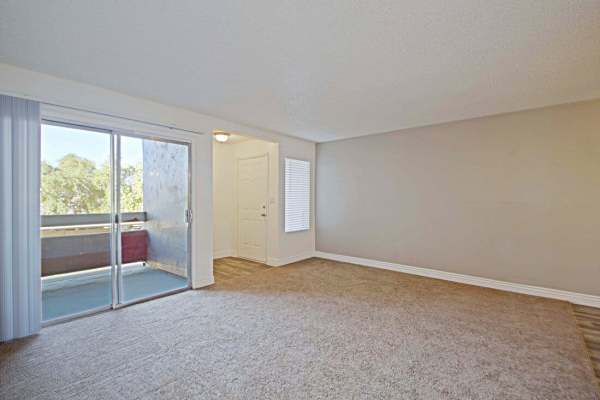 Empty apartment living room with a sliding glass door to access balcony at 544 Southern Apartments in Mesa,Arizona