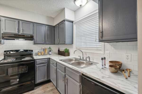 Kitchen with granite countertops, stainless steel sink, stove, dishwasher and microwave at Piccadilly Apartments in Goodlettsville, Tennessee