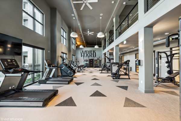 Modern fitness center at the 55+ community featuring cardio machines, strength equipment, and open space for wellness activities.