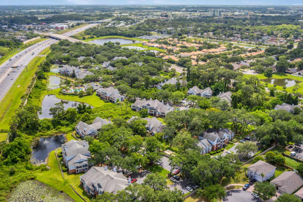 Aerial view of the community alongside a highway and a tranquil lake at Rosemont Windermere in Orlando, Florida