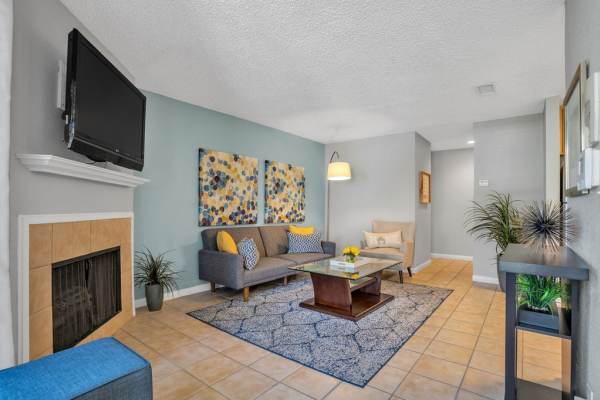 Living room with table and recliners at The Canopy Apartment Villas in Orlando, Florida