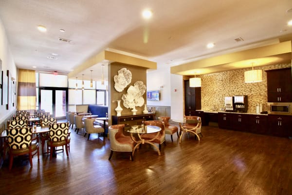Bright and inviting breakfast lounge with tables and chairs neatly arranged, offering a comfortable space for residents to enjoy morning meals.