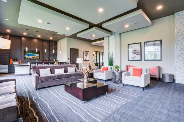 Spacious community lounge with couches and large windows at Addison at Tampa Oaks in Temple Terrace, Florida