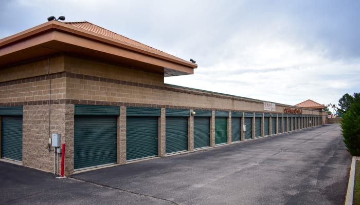 Green exterior storage unit doors and a wide driveway at a STOR-N-LOCK Self Storage location