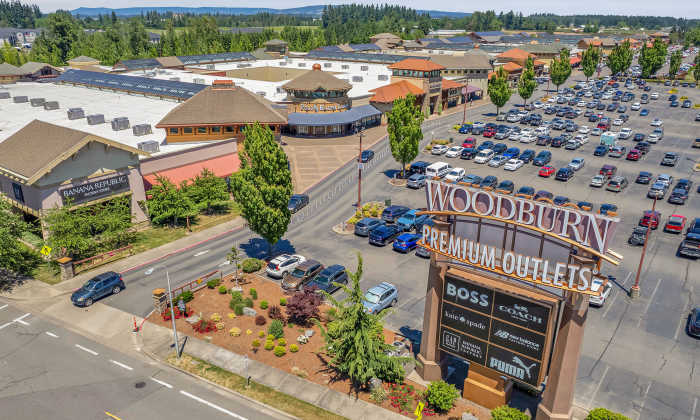 Aerial view of a shopping center with multiple stores and a large parking lot at Tilian Point in Woodburn, Oregon