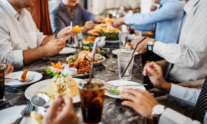 Group of people enjoying a meal at a dining table with various dishes and drinks near Tilian Point in Woodburn, Oregon