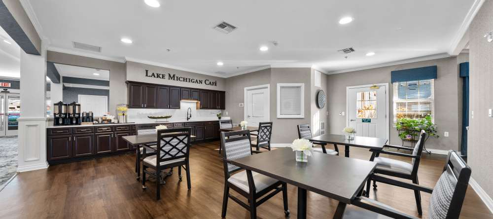 Café area with dark wood cabinets, dining tables, and bright overhead lighting