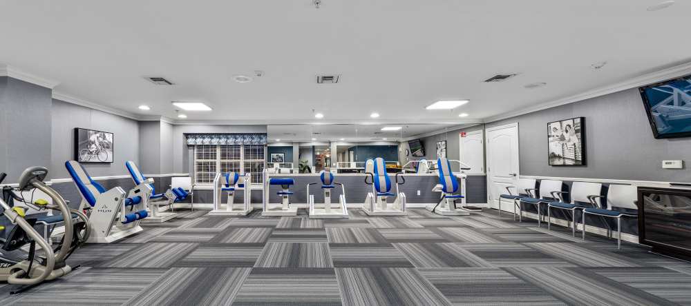 Fitness room with strength machines and padded flooring at Waltonwood Cherry Hill in Canton