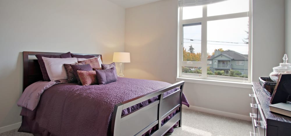 Large model bedroom with plush carpeting and great natural light at Motif Apartments in Lynnwood, Washington