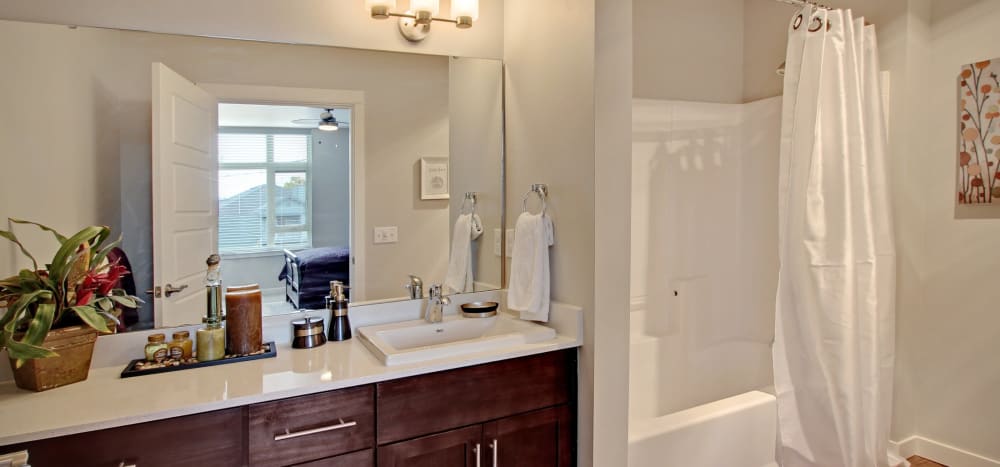 Model bathroom with a tub/shower combination at Motif Apartments in Lynnwood, Washington