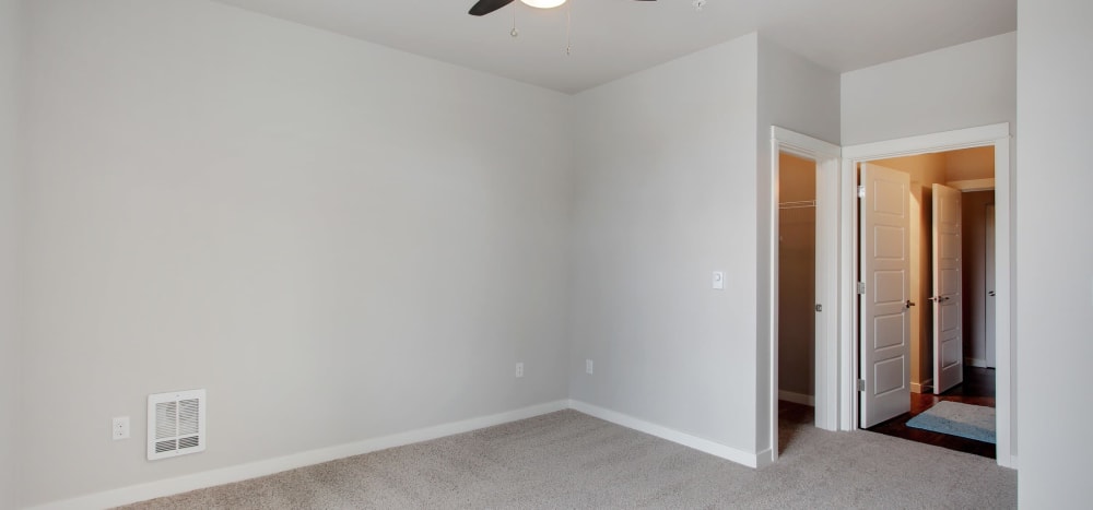 Model bedroom with a ceiling fan and wall-to-wall carpeting at Motif Apartments in Lynnwood, Washington