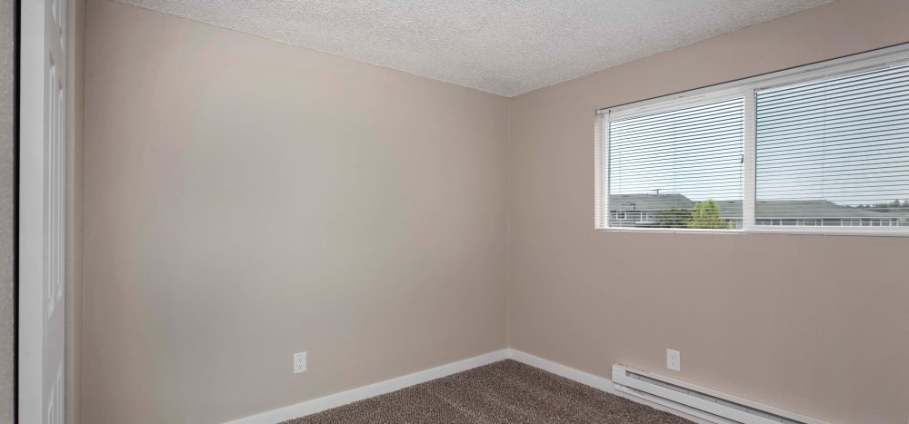 Bedroom with plush carpeting at Heights at Sheridan in Bremerton, Washington