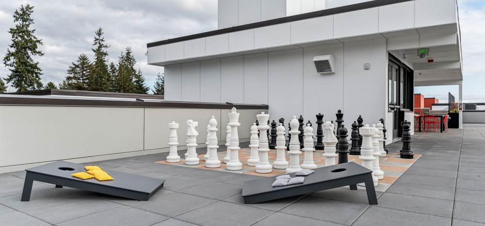 Socialize with neighbors while playing cornhole or chess on the roof deck at Traxx Apartments in Mountlake Terrace, Washington 