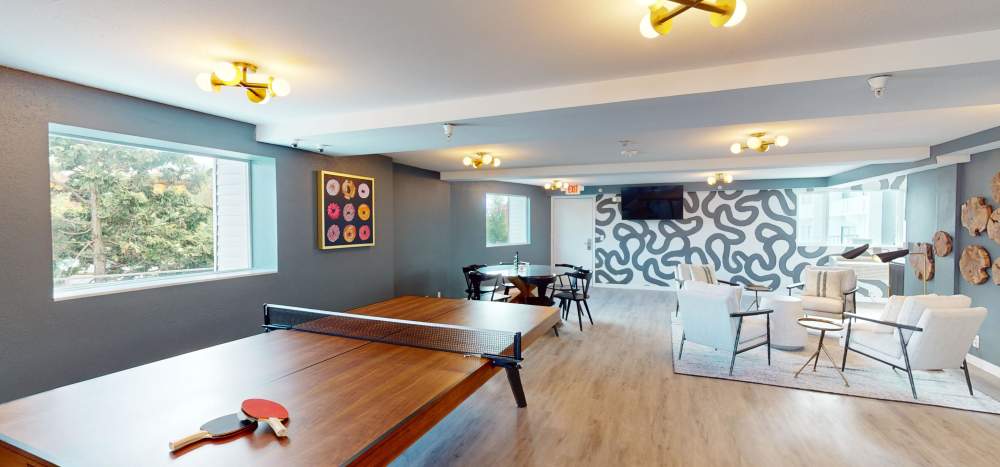 Community lounge with game tables at Thea Apartments in Tacoma, Washington
