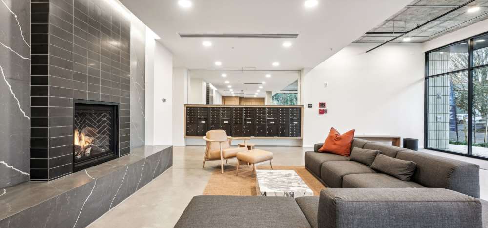 Community lounge with fireplace and technology workstations at Rothko Residences in Portland, Oregon