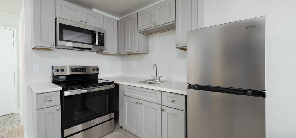  L -Shape Kitchen with stainless steel appliances at  Thea Apartments in Tacoma, Washington