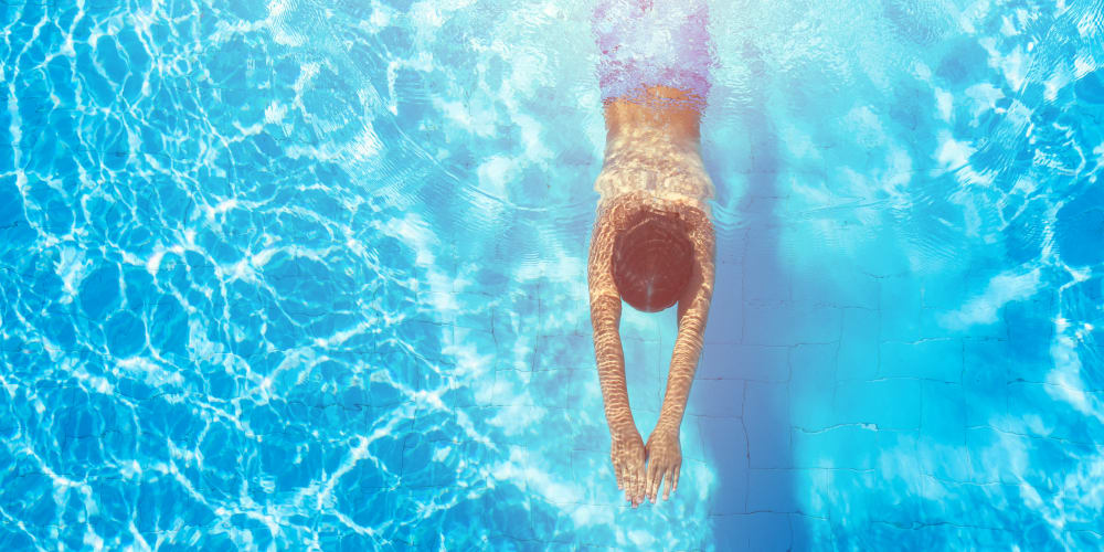 Woman relaxing next to the pool in Lawrenceville, New Jersey at Steward's Crossing Apartment Homes