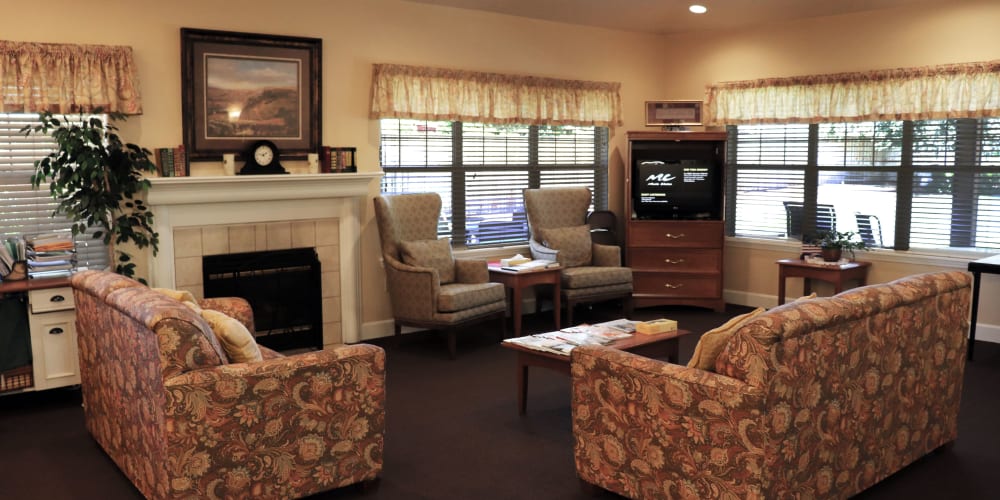 Communal sitting area complete with comfortable sofas, television set and fireplace at The Springs at Willowcreek in Salem, Oregon