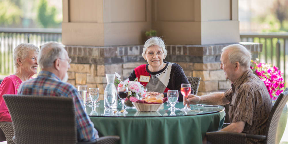 Smiling resident at a meal with friends at The Springs at Veranda Park in Medford, Oregon