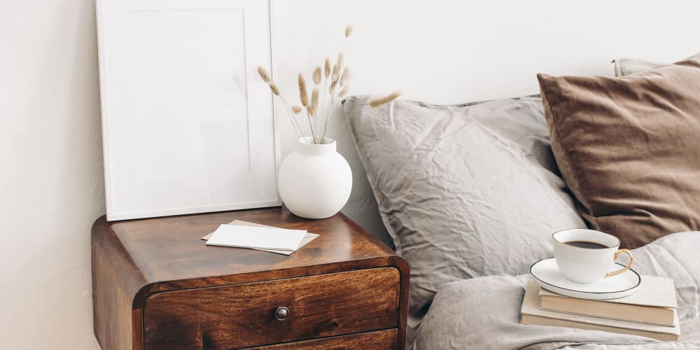 Bedside table with a vase containing wheat at a The Blake community