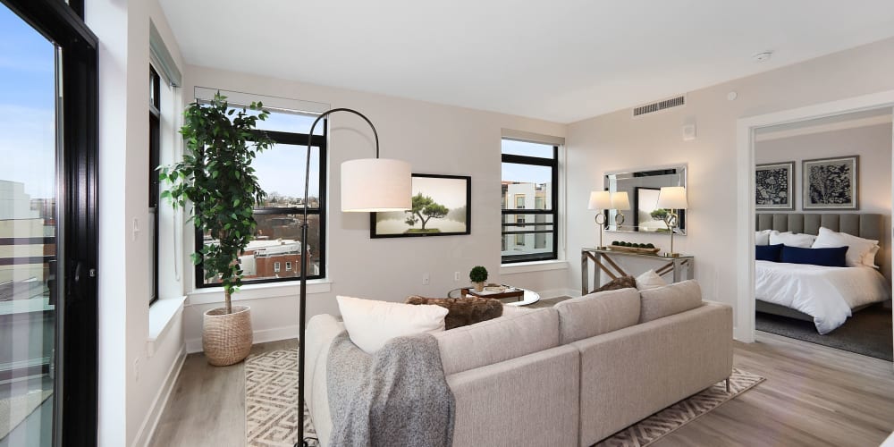 Spacious living room with hardwood style flooring in a model home at Madrona Apartments in Washington, District of Columbia