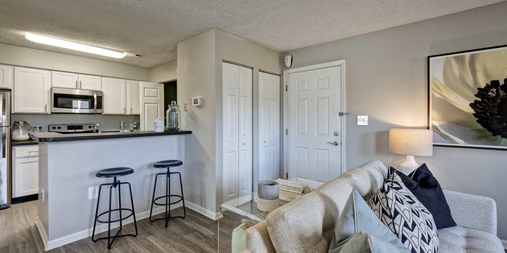 An apartment kitchen and a furnished living room at Stewards Crossing Apartments in Lawrenceville, New Jersey