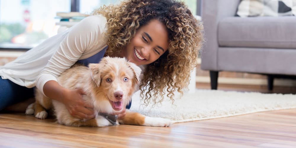 Resident and her puppy getting to know the beautiful hardwood flooring in their new apartment at Farmstead at Lia Lane in Santa Rosa, California