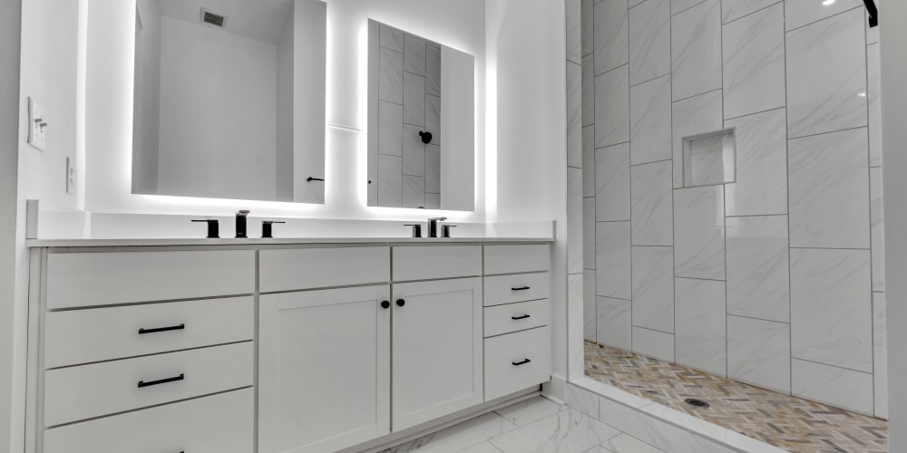 A modern bathroom with double vanity and walk-in shower at Theatre Lofts in Birmingham, Alabama