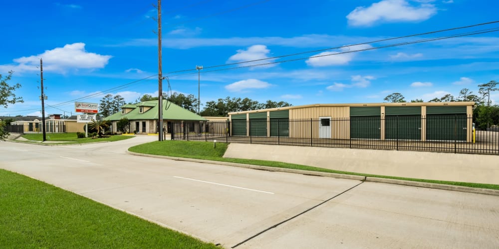 Outdoor storage units with a wide driveway at StorQuest Self Storage in Spring, Texas
