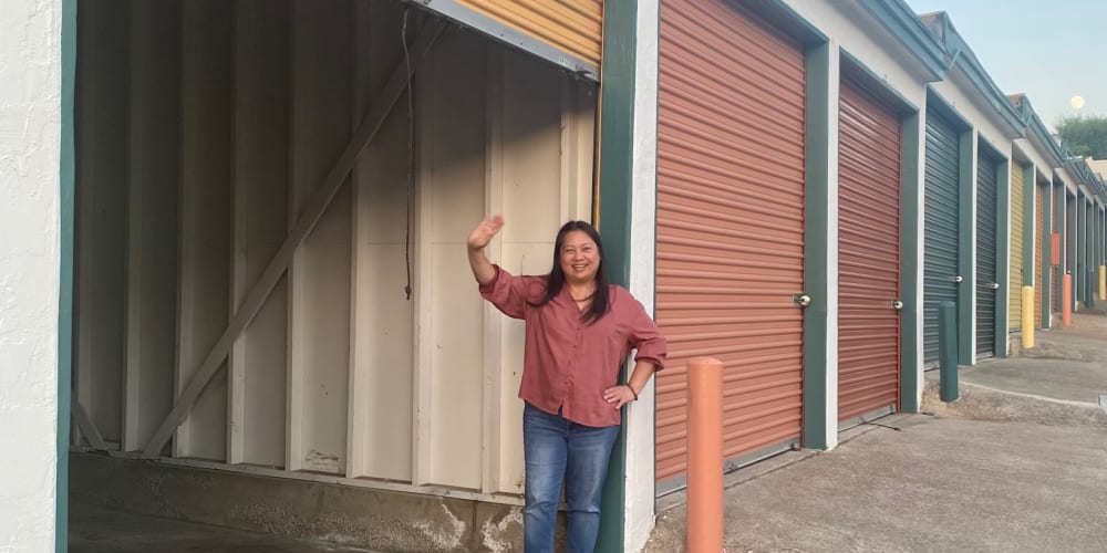 A smiling woman standing outside of a large unit at Storage Oasis in Santee, California