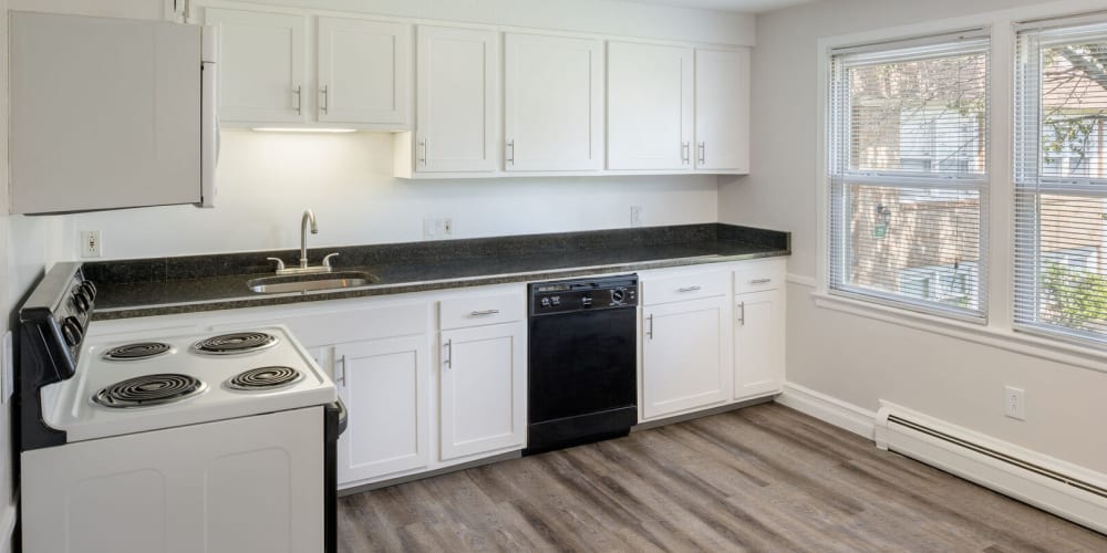 Apartment kitchen with black countertops at The Four Seasons Apartments in East Providence, Rhode Island