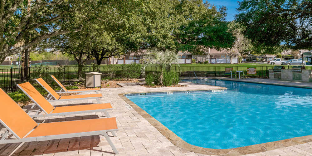 Lounge chairs next to the swimming pool at The Fredd Townhomes in San Antonio, Texas