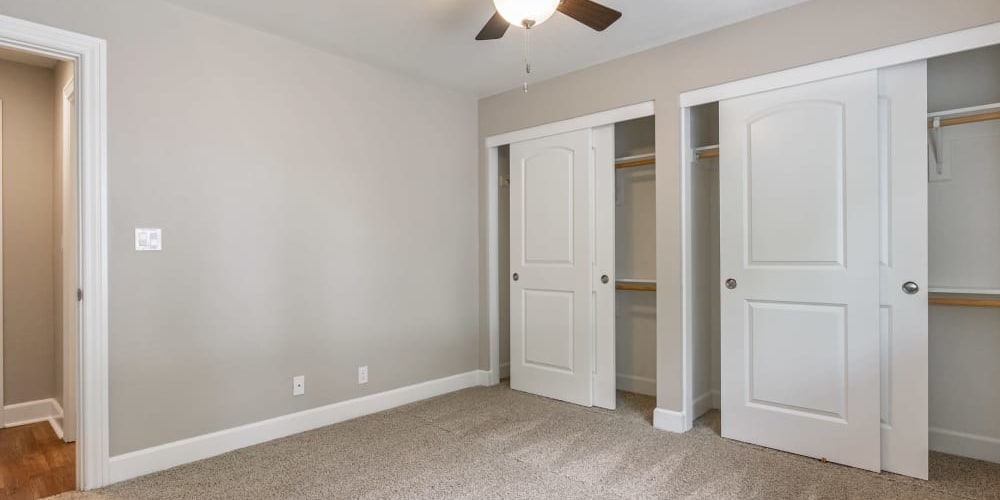 Bedroom with large closets and a ceiling fan at Pentagon Apartments in Fremont, California