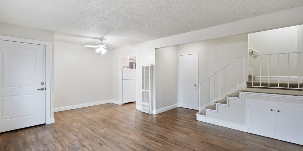 Spacious living area with wood-style flooring and a ceiling fan at Parkway Apartments in Fremont, California