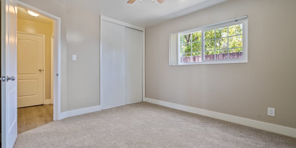 Bedroom with plush carpeting and large closet at Royal Gardens Apartments in Livermore, California