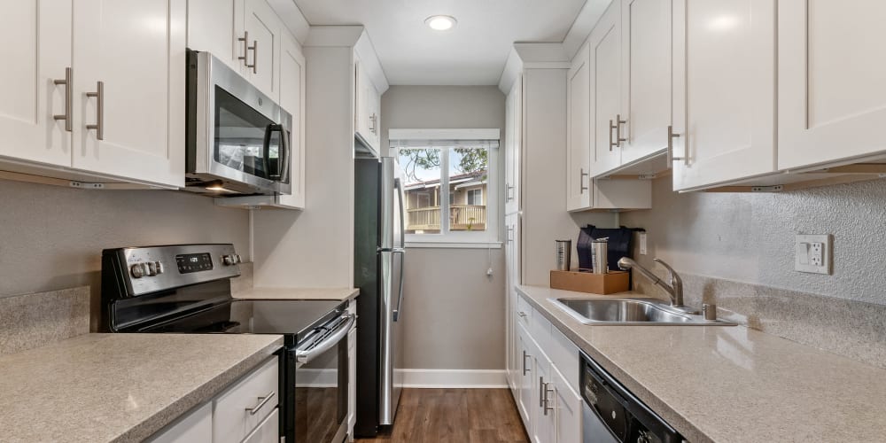 Gourmet kitchen with stainless-steel appliances and white cabinetry at Vista Creek Apartments in Castro Valley, California