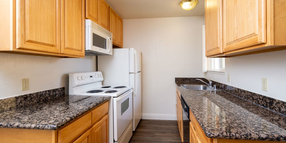 Fully equipped kitchen with white appliances at Peppertree Apartments in San Jose, California