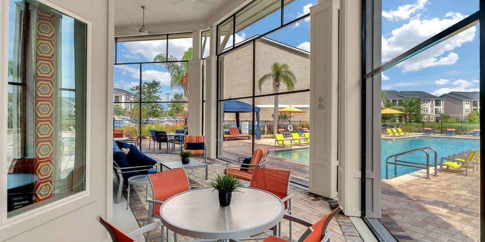 Screened in seating by the pool at Art Avenue Apartment Homes in Orlando, Florida