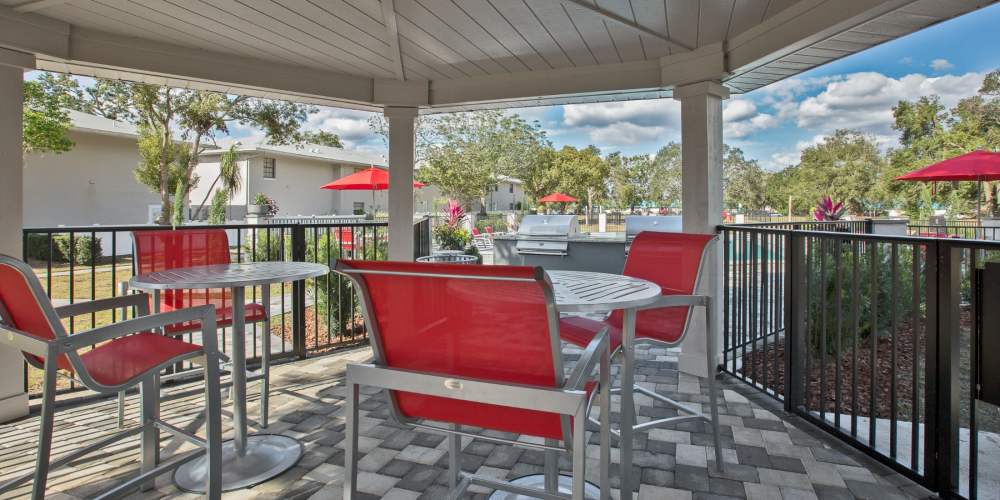 Covered patio seating by the pool at Barrington Place at Winter Haven in Winter Haven, Florida