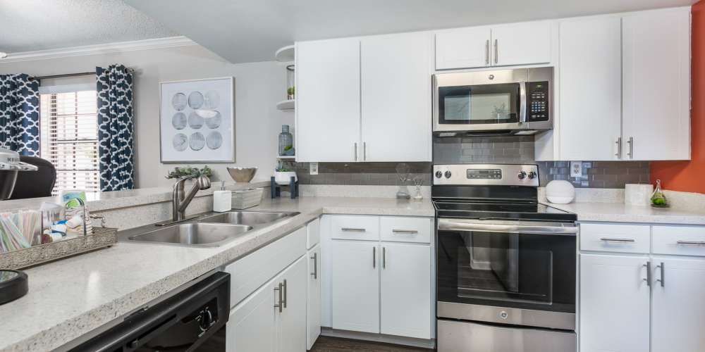 Apartment kitchen with white cabinets and stainless steel appliances at Barrington Place at Winter Haven in Winter Haven, Florida