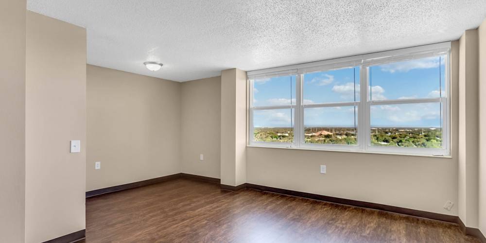 Spacious apartment living room with hardwood floors and scenic views at Bay Pointe Tower in South Pasadena, Florida