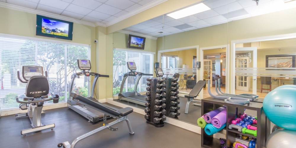 Community fitness center with free weights and cardio at Bay Pointe Tower in South Pasadena, Florida