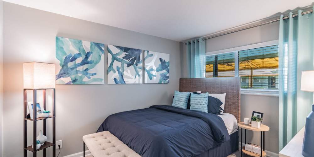 Furnished apartment bedroom with artwork on the walls at Bermuda Cay in Boynton Beach, Florida