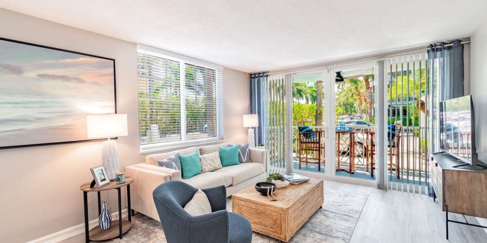 Furnished living room with several large windows at Bermuda Cay in Boynton Beach, Florida