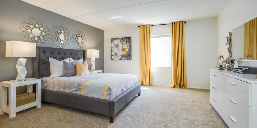 Carpeted apartment bedroom with matching end tables and lamps at Briarcrest at Winter Haven in Winter Haven, Florida